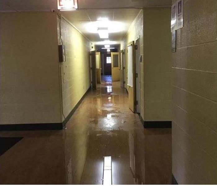 Long hallway with water on flooring